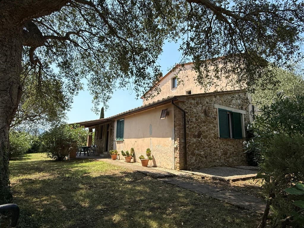 Wohnung Grilli mit Pfirsichfassade und grünen Fensterläden im Garten unter einer Olive